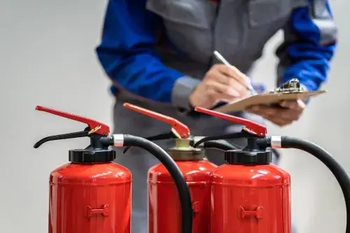 technician inspecting a fire extinguisher
